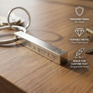 Personalized metal bar keychain with engraved GPS coordinates placed on wooden surface showing premium finish