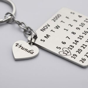 Close-up of engraved name charm and highlighted date on stainless steel calendar keychain