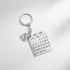 Custom engraved calendar date keychain photographed under soft white lighting