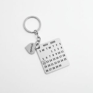 Single custom calendar keychain with engraved name charm on white background