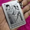 A metal pendant with a photo and text engraved on it attached to a metal key ring.