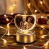 Customized apple crystal photo lamp with engraved couple portrait, soft golden lights, romantic heart-bokeh background for anniversary gift.