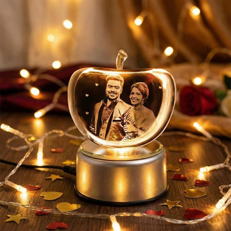 Customized apple crystal photo lamp with engraved couple portrait, soft golden lights, romantic heart-bokeh background for anniversary gift.