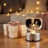 Personalized apple crystal photo lamp placed beside gift box, warm lights and heart decorations, perfect anniversary or wedding gift.