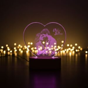 Heart-shaped customized LED photo lamp with engraved family picture, placed on a bedside table in a cozy room setting