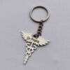 A personalized metal keychain for doctors with a Rod of Asclepius and an engraved name tag.