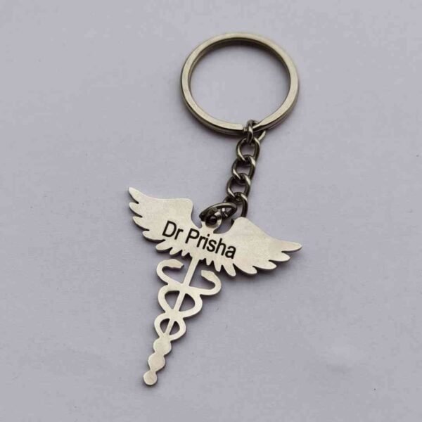 A personalized metal keychain for doctors with a Rod of Asclepius and an engraved name tag.