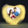 A white heart shape LED cushion pillow with a photo of a smiling couple on it