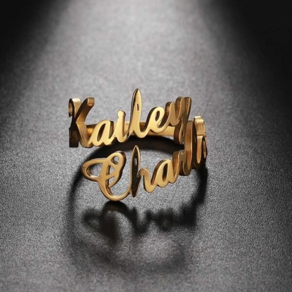 A close-up of a Gold Lovely Name Ring with a custom engraving of a name on it, wrapped in a red gift box with a ribbon. Perfect for Valentine's Day.