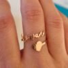 A close-up of a Gold Adjustable Name Ring with a custom name on it, showing the adjustable feature of the ring.