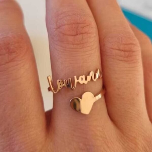 A close-up of a Gold Adjustable Name Ring with a custom name on it, showing the adjustable feature of the ring.