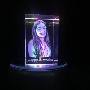 3D laser-engraved crystal displaying a smiling woman's portrait with 'Happy Birthday' inscription, illuminated by an LED light base.
