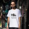 Man wearing a white t-shirt with cartoon dog graphic and text 'Nothing better than naps with the dog' in an urban setting.