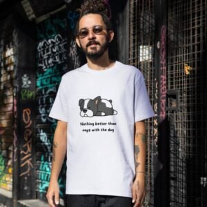 Man wearing a white t-shirt with cartoon dog graphic and text 'Nothing better than naps with the dog' in an urban setting.