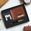 Customized gift set for men featuring a brown leather wallet with Your Name engraved, two keychains with romantic coordinates, and a personalized pen with golden flakes, presented in a sleek black box.