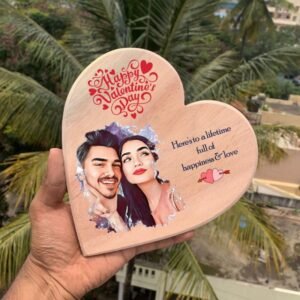 Hand-held personalized wooden heart plaque featuring a portrait of a couple, with Valentine's Day wishes and a love quote.