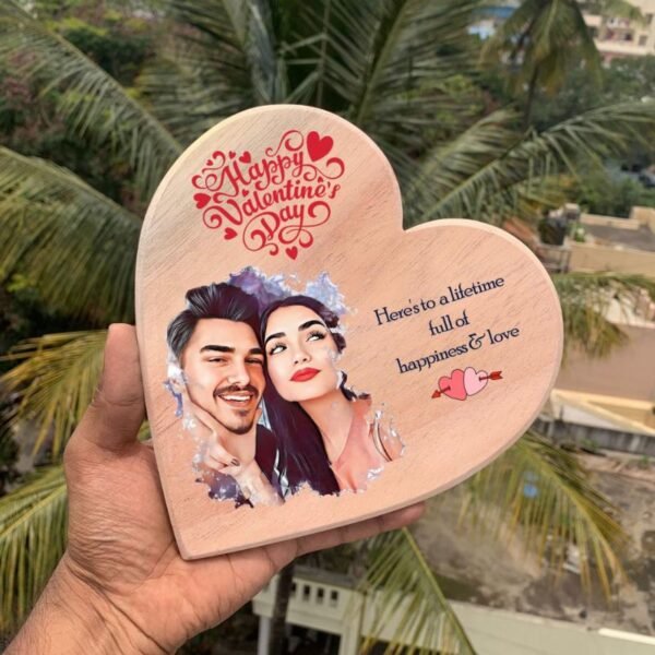 Hand-held personalized wooden heart plaque featuring a portrait of a couple, with Valentine's Day wishes and a love quote.