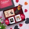Open Valentine's Day gift set box containing personalized photo wooden plaque, mugs, and chocolates, with 'Mr. Right' and 'Mrs. Always Right' designs, surrounded by romantic decorations.