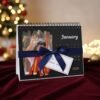 Gift-wrapped personalized 2026 table calendar with custom photo and navy-blue ribbon, perfect for gifting.