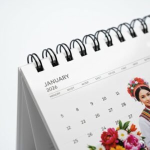 Premium spiral binding and glossy laminated pages of personalized 2026 desk calendar.