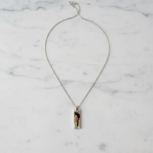 Rectangular photo engraved necklace with custom picture, minimal studio shot on beige background