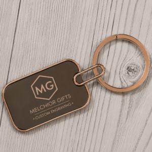Personalised metal dog-tag keychain with rose-gold rim and laser-engraved logo