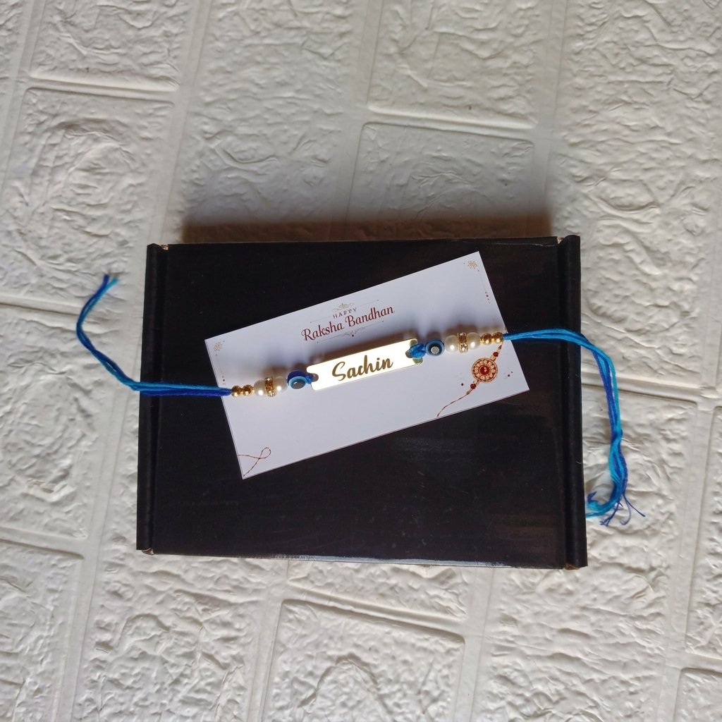 Personalised Bhai Name Rakhi – Evil Eye & Pearl Blue Thread with Gift Box & Card — lifestyle photo in real gifting setting