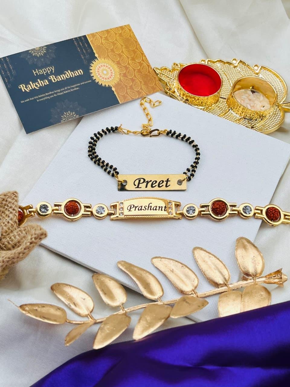 Personalised bhaiya bhabhi set with rudraksha and crystal stone name bracelet rakhi, black-bead mangalsutra name bracelet for bhabhi, gold roli-chawal thali and Happy Raksha Bandhan greeting card