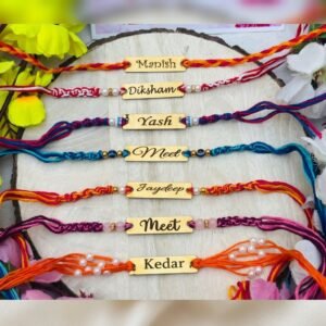 Seven personalised handmade braided name thread rakhis with engraved gold-tone name plates laid on a wooden slice