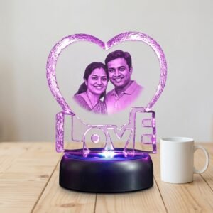 Heart LOVE photo crystal shown beside a coffee mug for scale, about 14 cm across on its rotating LED base