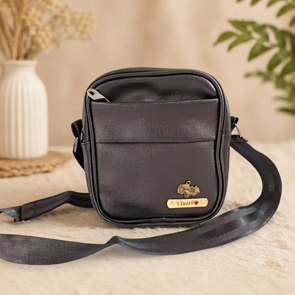 Personalised black sling bag for men with engraved name plate and charm
