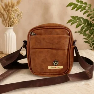 Personalised tan sling bag for men with engraved gold name plate and charm